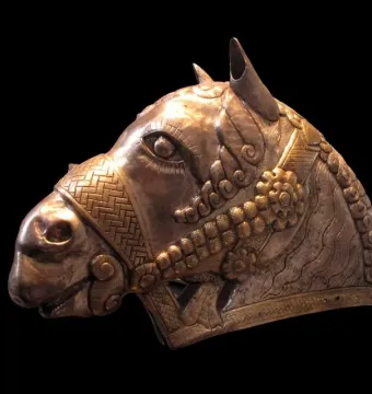 Sassanian horse head sculpture in profile with silver-toned metal and gold embellishments.