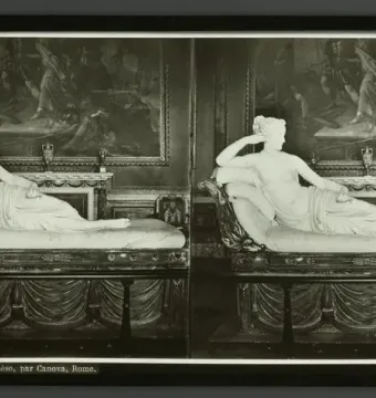 Reclining white marble statue of Venus Victrix on an ornate chaise lounge in a gallery room
