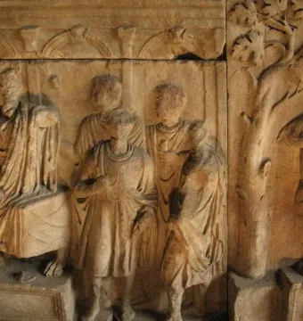 The Plutei of Trajan marble relief showing draped figures beside a tree and an altar with an eagle.