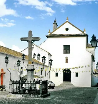 Christ of the Lanterns stone crucifix surrounded by lanterns in a cobblestone square.