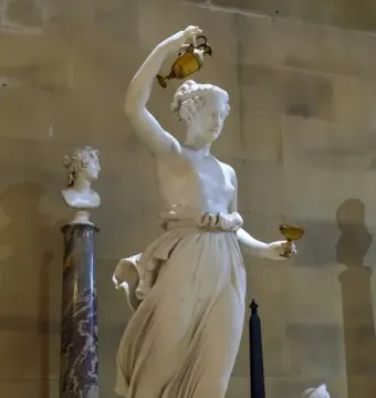 Hebe, a white marble statue of a female figure holding a golden ewer and goblet