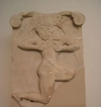 Runner Relief on a stone stele, showing a carved male figure in a forward-leaning stance on a dark pedestal.