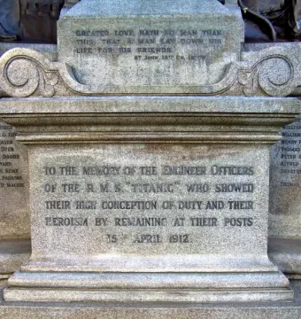 Inscribed stone base of the Titanic Engineers\' Memorial with dedication text and a biblical verse.