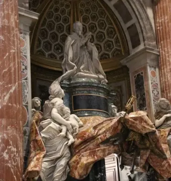 Tomb of Pope Alexander VII showing a kneeling figure above a flowing marble drapery and a skeletal figure with an hourglass and spear below, with white marble allegories at the base.