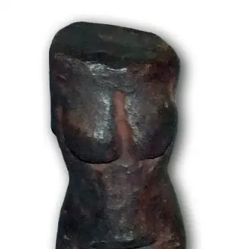 Replica of the Venus of Petrkovice showing a dark prehistoric female torso with pronounced breasts and hips.