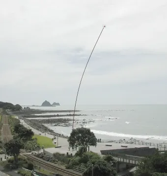 Wind Wand sculpture on the New Plymouth waterfront beside the sea and railway tracks.