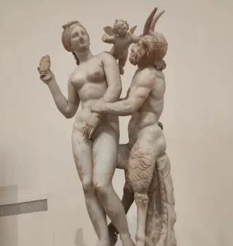 Aphrodite, Pan and Eros marble sculpture group showing a nude woman with a shell, a horned figure embracing her, and a small winged figure on her shoulder.