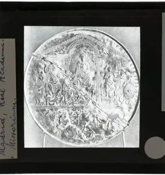 Disc of Theodosius shown as a circular relief with an enthroned emperor and attendants, cracked diagonally and mounted in a black frame.