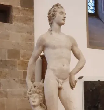 Marble sculpture of Apollo and Hyacinth showing a standing nude male figure and a kneeling figure beside him.