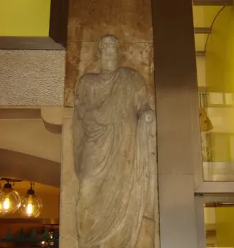 Scior Carera stone relief of a draped male figure with a Latin inscription below.