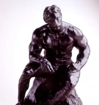 The Athlete, a dark metallic sculpture of a muscular seated man leaning forward on a rocky base.