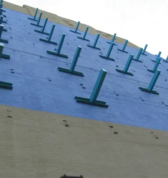 The Wall at Gateway to Soho, showing a blue upper section with teal T-shaped protrusions over a tan lower wall.