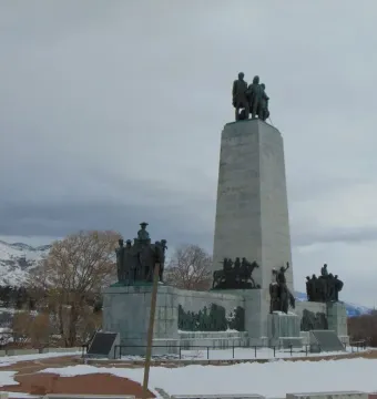This Is the Place Monument with bronze pioneer figures, horses, and wagons at its base