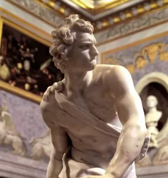 Bernini\'s David sculpture showing a marble figure gripping a sling and looking sharply to the right.