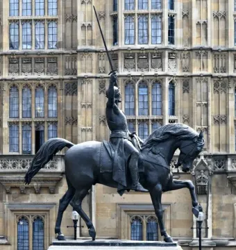 The Richard Coeur de Lion equestrian statue of King Richard I with sword raised in front of the Palace of Westminster.
