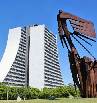 Monument to the Azoreans, a rust-colored abstract metal sculpture with human figures and a sweeping ship-like form against the sky.