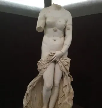 Venus Landolina, a headless white marble female statue with a missing right arm, holding drapery over her lower body.