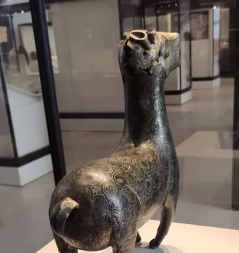 Bronze statuette of the Ciervo de Madinat al Zahra with a damaged, mostly missing head and a hollow opening at the top.