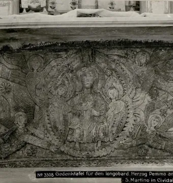 Carved stone panel from the Rachis Altar with a haloed central figure, smaller saints, angels, and ornate foliage reliefs.