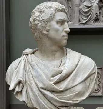 Marble bust of Brutus shown in sharp profile with curly hair and draped clothing.