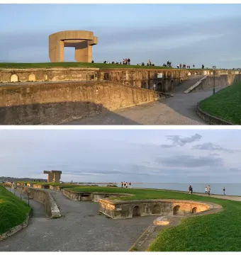 Elogio del Horizonte concrete sculpture on a grassy hill with visitors and the sea in the background.