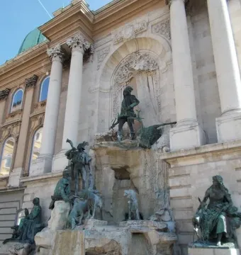 Fountain of King Matthias with bronze figures in front of a palace facade in Budapest
