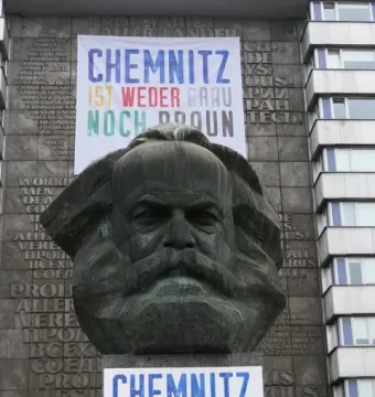 Karl Marx Monument in Chemnitz framed by two banners reading \