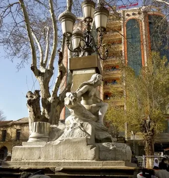 Ain El Fouara Fountain with a reclining female statue and ornate lamppost in Setif.