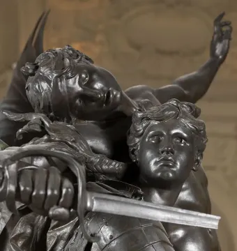 Close-up of Gloria Victis showing a winged bronze figure leaning over a wounded warrior with a sword.