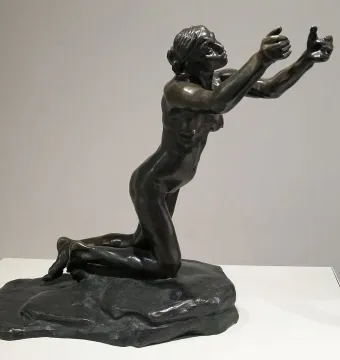 Camille Claudel\'s The Implorer, a dark bronze nude figure kneeling with arms outstretched and head tilted upward.