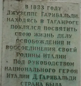Weathered rectangular plaque with deeply inscribed Cyrillic text on the Garibaldi Monument.