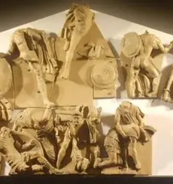 Talamone Pediment terracotta relief showing a crowded battle scene with warriors, horses, fallen figures, and a chariot rider.