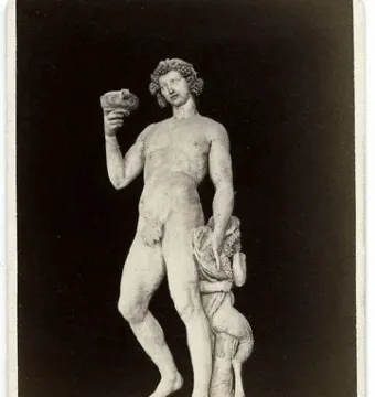 Michelangelo’s Bacchus, a marble statue of a nude male figure holding a goblet and grapes with a small satyr beside him.