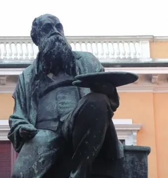Monument to Mosè Bianchi, a seated bearded statue holding a painter’s palette.