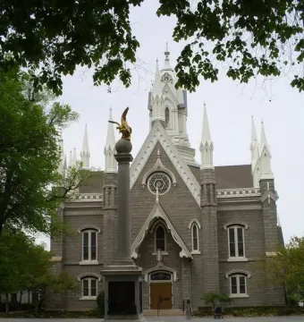 Seagull Monument in front of the Assembly Hall, with a golden bird statue atop a tall column and a stone building behind it.