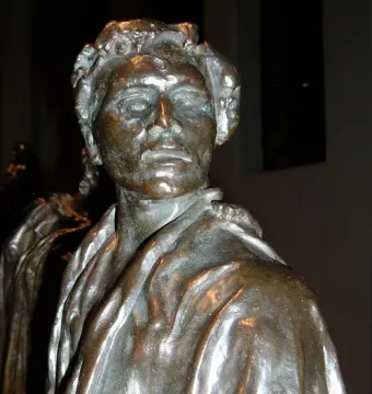 Jean de Fiennes bronze sculpture with a solemn face and heavy folded drapery over the shoulders and chest.
