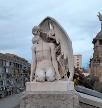 The Kiss of Death sculpture showing a winged skeletal figure embracing a kneeling man in a cemetery.