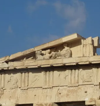 Parthenon pediment sculptures showing a reclining figure and a horse head against the sky.