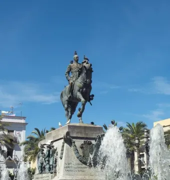 Bronze equestrian monument to Primo de Rivera on a tall stone pedestal, with fountains spraying around the base.
