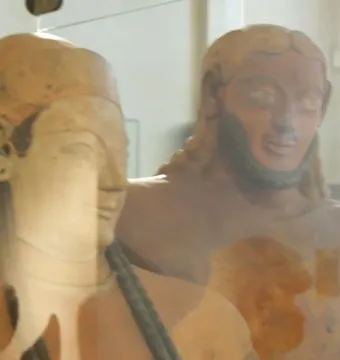 Close-up of the faces of the Sarcophagus of the Spouses, showing a female figure in front of a bearded male figure.