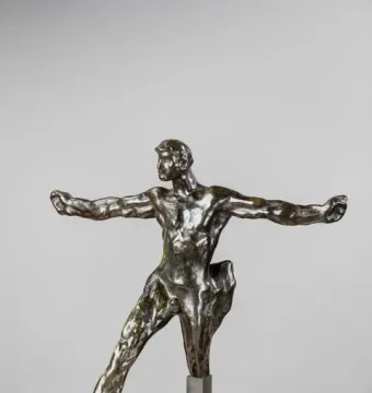 Standing Mercury bronze sculpture in a dynamic pose with outstretched arms and a dark textured form at the side.