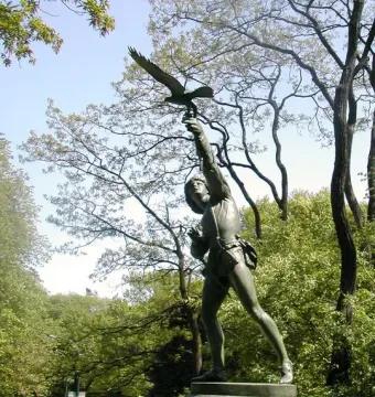 The Falconer bronze statue on a stone pedestal in Central Park, shown with a falcon on the raised arm.