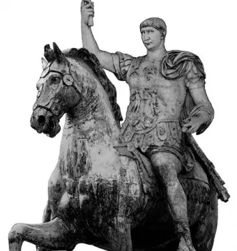 Trajan\'s equestrian statue showing an armored rider on a horse with one foreleg raised, holding an object aloft.