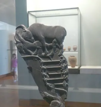 Bull Palette carved stone fragment showing a bull above a fallen figure and stepped scenes below.