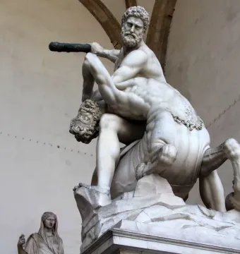 Heracles and Nessus, a white marble sculpture of a muscular man raising a club over a struggling centaur.