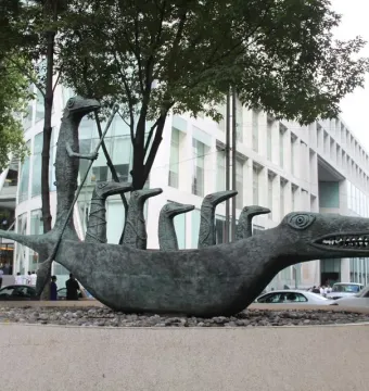 How Doth the Little Crocodile sculpture shaped like a reptile boat with a standing figure holding an oar.