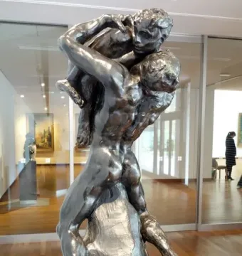 I Am Beautiful, a bronze sculpture showing a muscular male figure carrying a smaller figure on his back and shoulders.