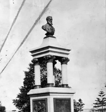 Maitland Brown Memorial stone monument topped with a bust and relief panels on a grassy site