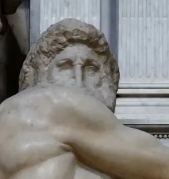 Close-up of Michelangelo’s Day, showing the marble figure’s head and muscular upper body with curly hair and deep-set eyes.