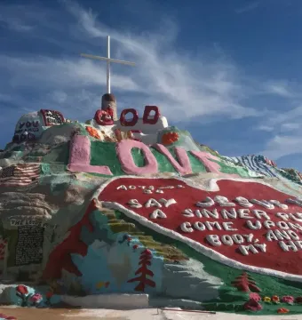 Salvation Mountain with a white cross, pink \
